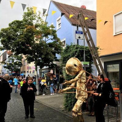 Bild vergrößern: Foto von Michael Pllmann, der mit einer goldenen Marionette durch die Breite Strae geht .
