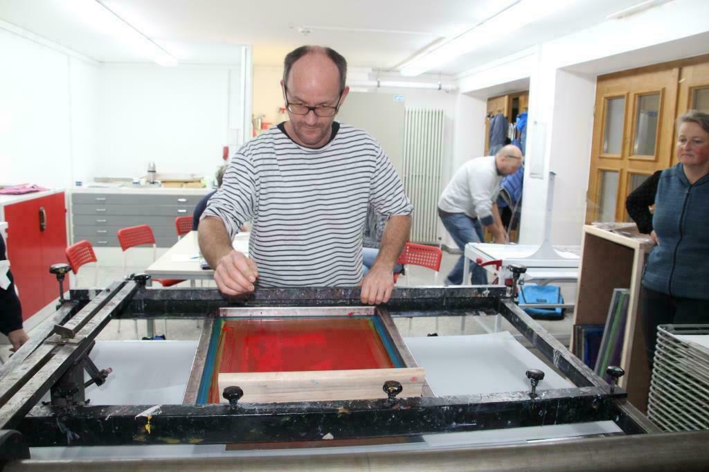 Bild vergrößern: Portrait des Kursleiters an der Siebdruckmaschine