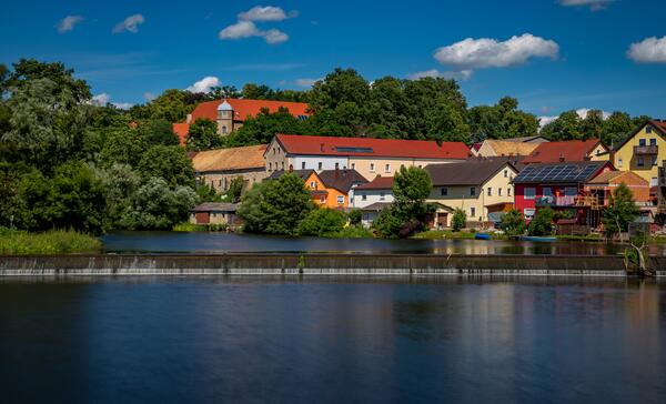 Bild vergrößern: Blick auf Schloss Fronberg. Es sind noch weitere Huser in bunten Farben und der Fluss Naab zu sehen.