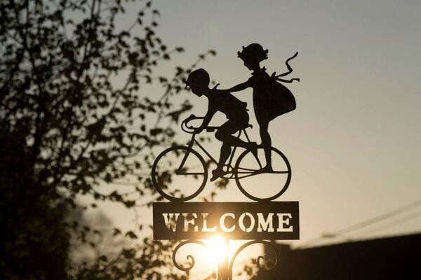 Bild vergrößern: Ein Belchschuld mit zwei Kindern auf einem Fahrrad, darunter steht "Welcome"