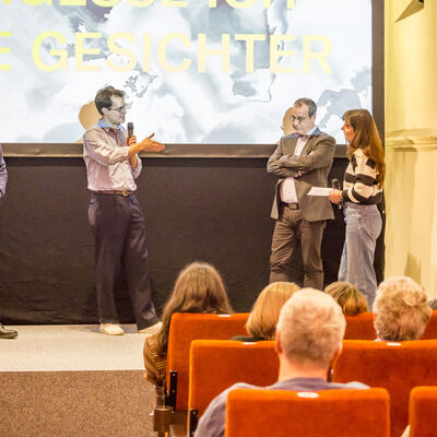 Die drei Gewinner des Bayerischen Dokumentarfilmpreises ZETT stehen auf der Bhne und sind im Gesprch mit der Moderatorin.