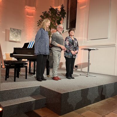 Der Knstler Peter Nesch steht zwischen den beiden Pianistinnen Eva Herrmann und Inna Schur auf der Bhne der Spitalkirche.