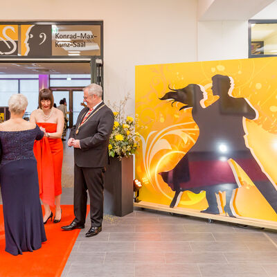 Foto von der Fotowand.
Fotowand zeigt ein tanzendes Paar vor einem gelben Hintergrund