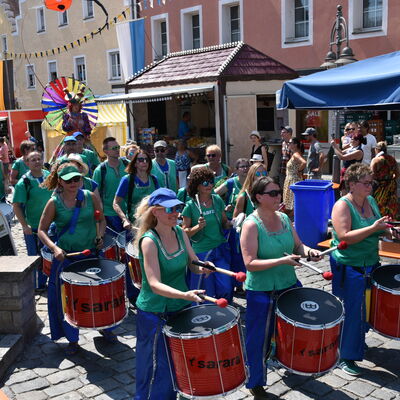 Bild vergrößern: Die grn-blau gekleideten Mitglieder der Trommelgruppe Sarar ziehen durch das Brgerfest.
