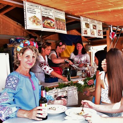 Bild vergrößern: Frauen in ukrainischer Tracht verkaufen traditionelle Gerichte aus ihrem Stand beim Schwandorfer Brgerfest