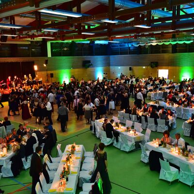 Foto in Vogelperspektive vom Stadtball in der Oberpfalzhalle. Die Halle ist grn erleuchtet. Menschen in Abendgarderobe tanzen auf der Tanzflche oder sitzen an festlich gedeckten Tischen.