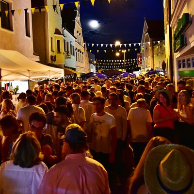 Bild vergrößern: Foto einer Menschmenge auf dem Schwandorfer Brgerfest 2017 bei Nacht. Die Strae ist mit bunten Fahnen geschmckt und hell erleuchtet.